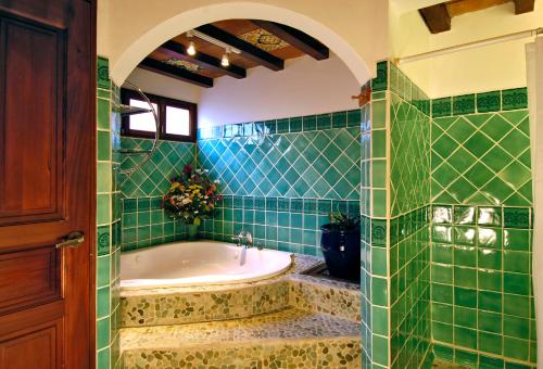 格拉纳达Hotel Colonial Granada的绿色瓷砖浴室设有浴缸和水槽