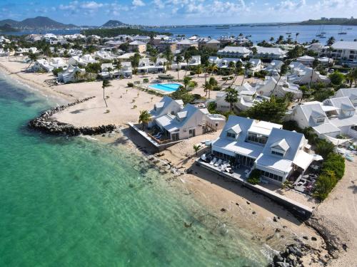 Baie NettleLa Plage Bleue feet in the water with swimming pool的享有海滩的空中景致,设有房屋和海洋