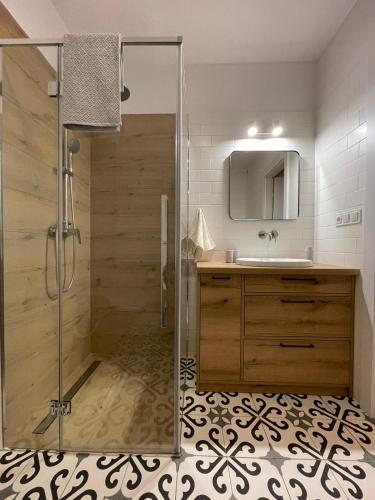 克罗斯诺APARTAMENTY GUZIK的带淋浴和盥洗盆的浴室