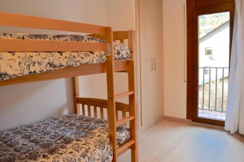 埃斯特里-德阿内乌Apartament comfortable amb vistes i cèntric by RURAL D'ÀNEU的一间卧室设有两张双层床和一扇窗户。