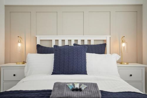 诺里奇Luxurious and Modern 3 Bed townhouse with Parking的一间卧室配有白色床和蓝色枕头