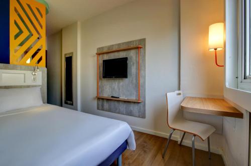 巴鲁埃里塔博瑞宜必思经济酒店的一间卧室配有一张床、一张书桌和一台电视。