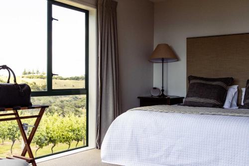 图图卡卡Vineyard Apartment的一间卧室设有一张床和一个大窗户