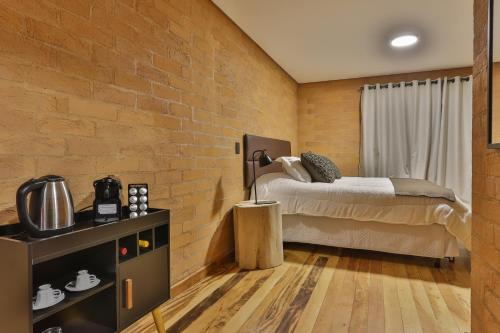 坎波斯杜若尔当DOM Hotel Boutique的一间卧室设有一张床和砖墙