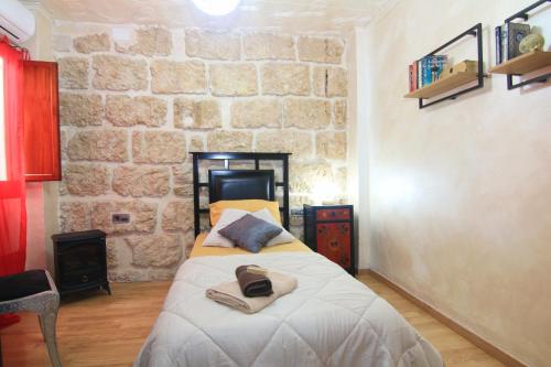 贝尼萨Casa Marrón Boutique Home的一间卧室设有一张床和石墙