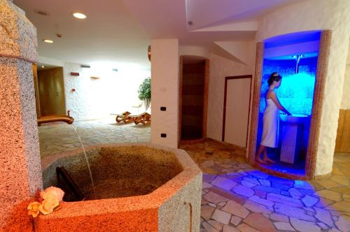 摩德纳迪-坎皮格里奥卡罗芒果温泉假日酒店的站在带浴缸的浴室中的女人