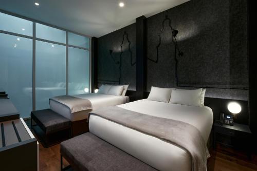 昆卡Casa Firenza Hotel & Suites Boutique的酒店客房设有两张床和窗户。
