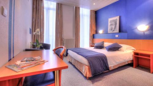 蒙斯特米努斯酒店的配有一张床和一张书桌的酒店客房