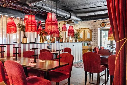 卡尔斯塔德Best Western Hotel Savoy的一间带桌子和红色椅子的用餐室