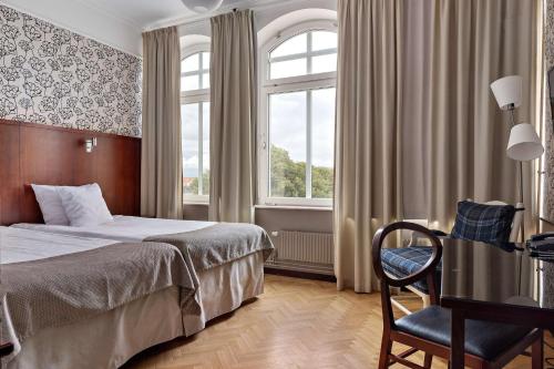 哈尔姆斯塔德哈尔姆斯塔德贝斯特韦斯特普拉斯大酒店的卧室配有床、椅子和窗户。