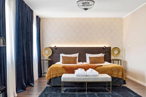卡尔斯塔德Best Western Hotel Savoy的一间卧室配有一张大床和金色床罩