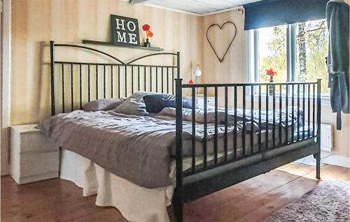 Aneby2 Bedroom Stunning Home In Aneby的卧室配有一张黑色的床,墙上挂着心印