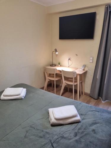 阿尔马达Isabel Guest House的一间卧室配有书桌和一张带两条毛巾的床。
