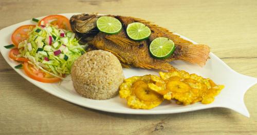 圣玛尔塔Hotel Los Veleros Santa Marta的桌上一盘带鱼和蔬菜的食物
