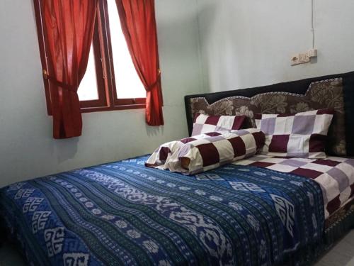 龙目岛库塔Sulis homestay的卧室内的一张床铺,带窗户
