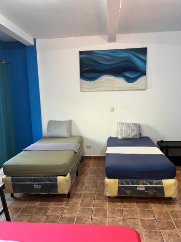 TamaniqueCasa Makoi的配有2张床的蓝色和白色墙壁客房