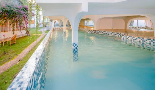 邦美蜀Vườn Pháp 3 Homestay的蓝色建筑中的游泳池