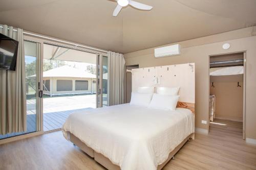 哈灵顿Crowdy Bay Eco Resort的一间带大床的卧室和一个阳台