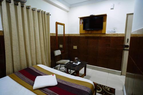 迈索尔HOTEL PRAKAASH RESIDENCY的一间酒店客房,配有一张床和一台电视