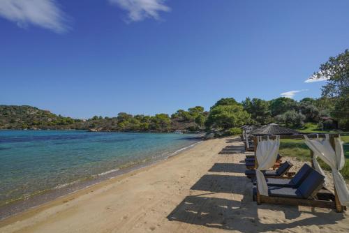 奥马斯帕纳吉亚斯Serenity Estate的海滩上的一排椅子和遮阳伞
