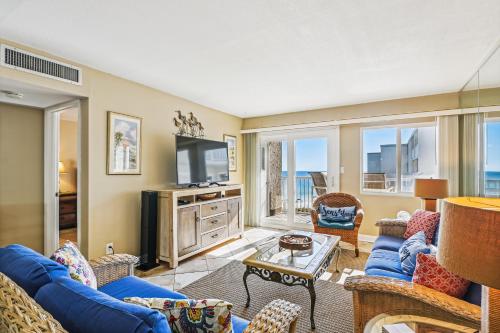 德斯坦Holiday Surf & Racquet 614 Condo的客厅配有蓝色的沙发和电视