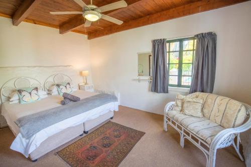 蒙塔古古卡鲁自助式旅馆的一间卧室配有两张床、一张沙发和吊扇