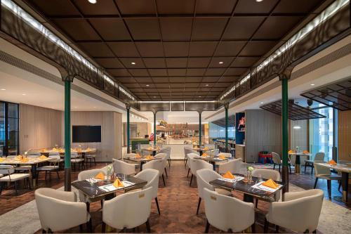 重庆重庆朝天门voco酒店的餐厅的 ⁇ 染,配有桌椅