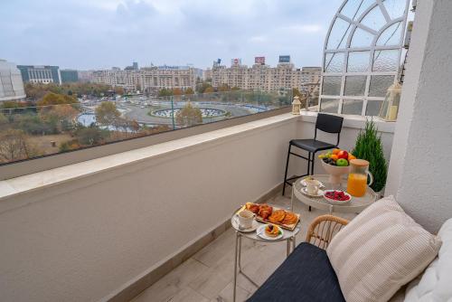 布加勒斯特Style and view Bucharest city center aparthotel的阳台配有餐桌,上面有食物
