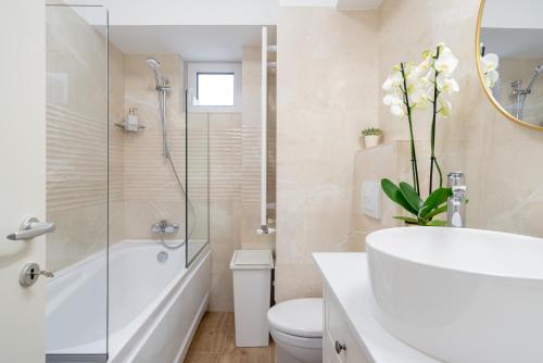 布加勒斯特Style and view Bucharest city center aparthotel的浴室配有白色浴缸、卫生间和水槽。
