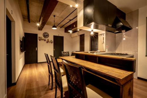 小樽IPPO生活小屋公寓式酒店的厨房配有带椅子和水槽的木台面