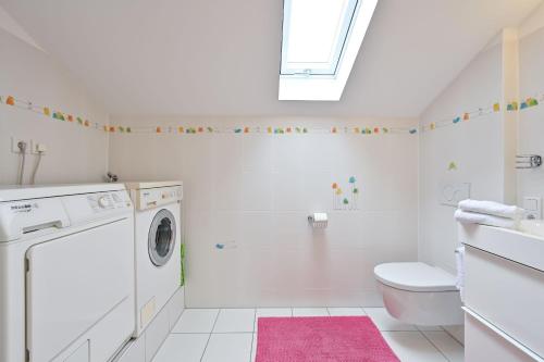 施万高Ferienwohnung Landhaus Helga unterm Schloss的白色的浴室设有洗衣机和粉红色地毯。