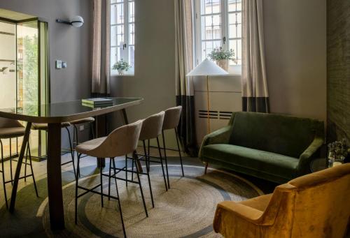 帕尔马Bellacorte Gentiluogo per Viaggiatori的客厅配有绿色沙发、桌子和椅子