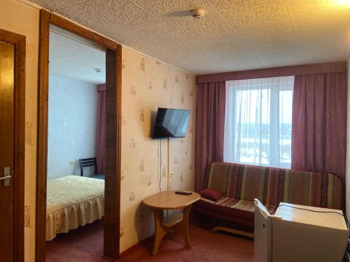 叶尔加瓦Riverside Motel Jelgava的酒店客房设有沙发、床和镜子