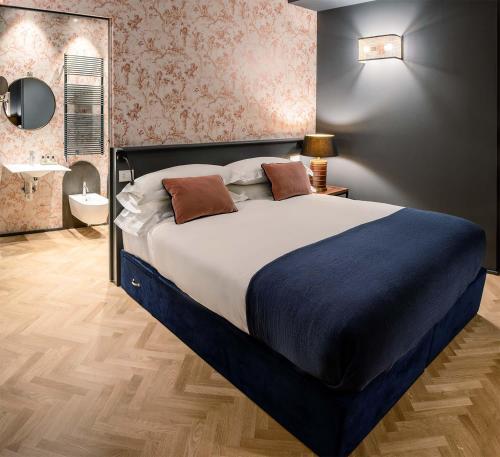 帕尔马Bellacorte Gentiluogo per Viaggiatori的一间带大床的卧室和一间浴室