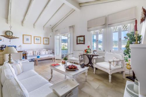 斯科派洛斯Skopelos Village Hotel的客厅配有白色家具和窗户。