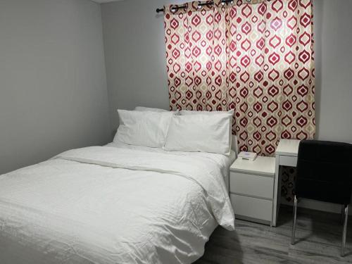 温尼伯Cozy Modern and Lavish 1 Bedroom Basement Suite的一间卧室配有床和红色及白色窗帘