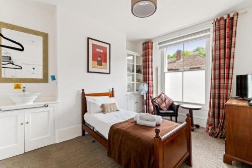多佛尔Dover Town Rooms - Short Lets & Serviced Accommodation - Dover的一间卧室配有床、水槽和窗户