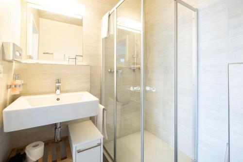 斯普赖滕巴赫Tailormade Hotel IDEA Spreitenbach的一间带水槽和淋浴的浴室