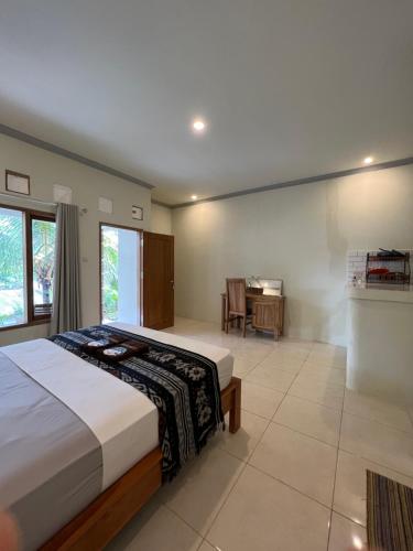 龙目岛库塔Kuta Circle Homestay的一间卧室配有一张床和一张书桌