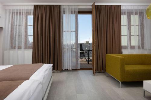 奥洛穆茨OREA Hotel Arigone Olomouc的酒店客房,配有床和黄色椅子
