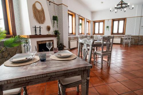比拉夫洛尔Hotel El Tejar & Spa的一间带桌椅和壁炉的用餐室