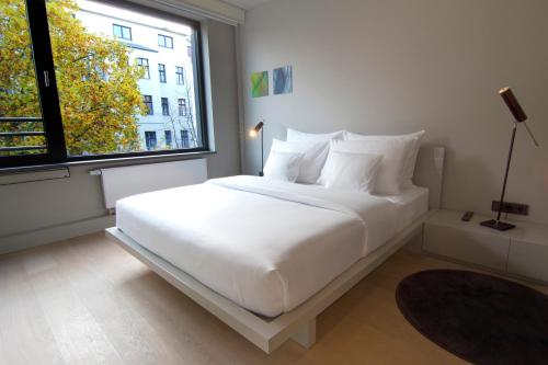 柏林SANA Berlin Residence的配有大窗户的客房内的白色床