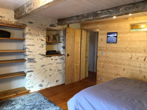 PlanayLes gîtes du Mistouflon的一间卧室设有一张床和石墙