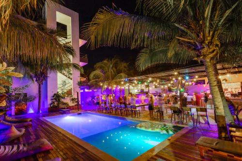 奥尔沃克斯岛Che Holbox Hostel & Bar Adults Only的一群人晚上坐在游泳池周围