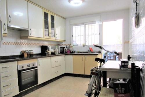 阿利坎特Victoria Hospedaje的厨房配有白色橱柜,里面停放着自行车