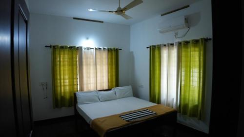 阿鲁法Thas apartment的一间小卧室,配有绿色窗帘和床
