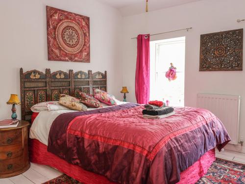库珀Wonderland Cottage的一间卧室配有一张带红色毯子的床和窗户。