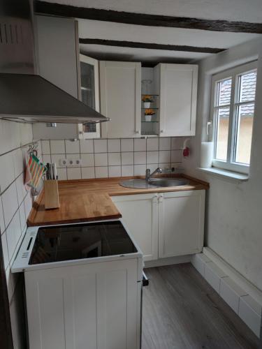 陶努斯山麓霍夫海姆Apartment Hofheimer Altstadt的厨房配有白色橱柜和炉灶烤箱。
