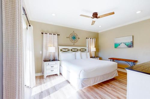 圣乔治岛Serenity Now的卧室配有白色的床和吊扇