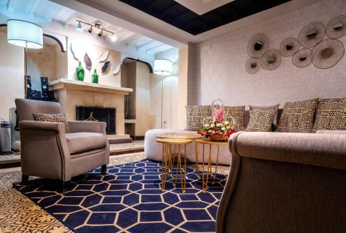 马拉喀什Riad La Croix Berbere De Luxe的客厅配有沙发、椅子和壁炉